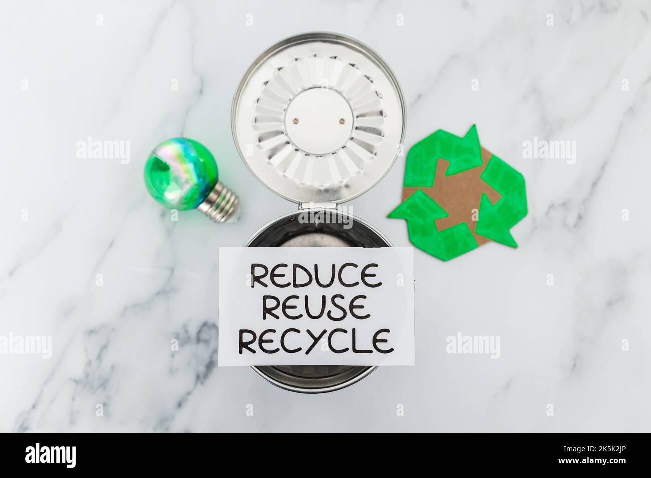 reduce reuse recycle sign with mini trash can next to green light bulb ...
