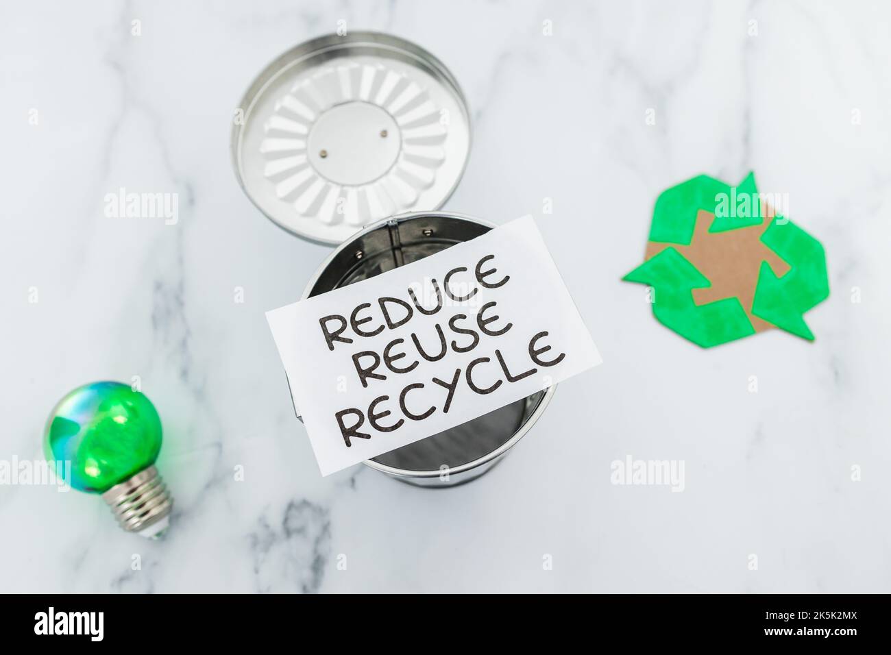 reduce reuse recycle sign with mini trash can next to green light bulb ...