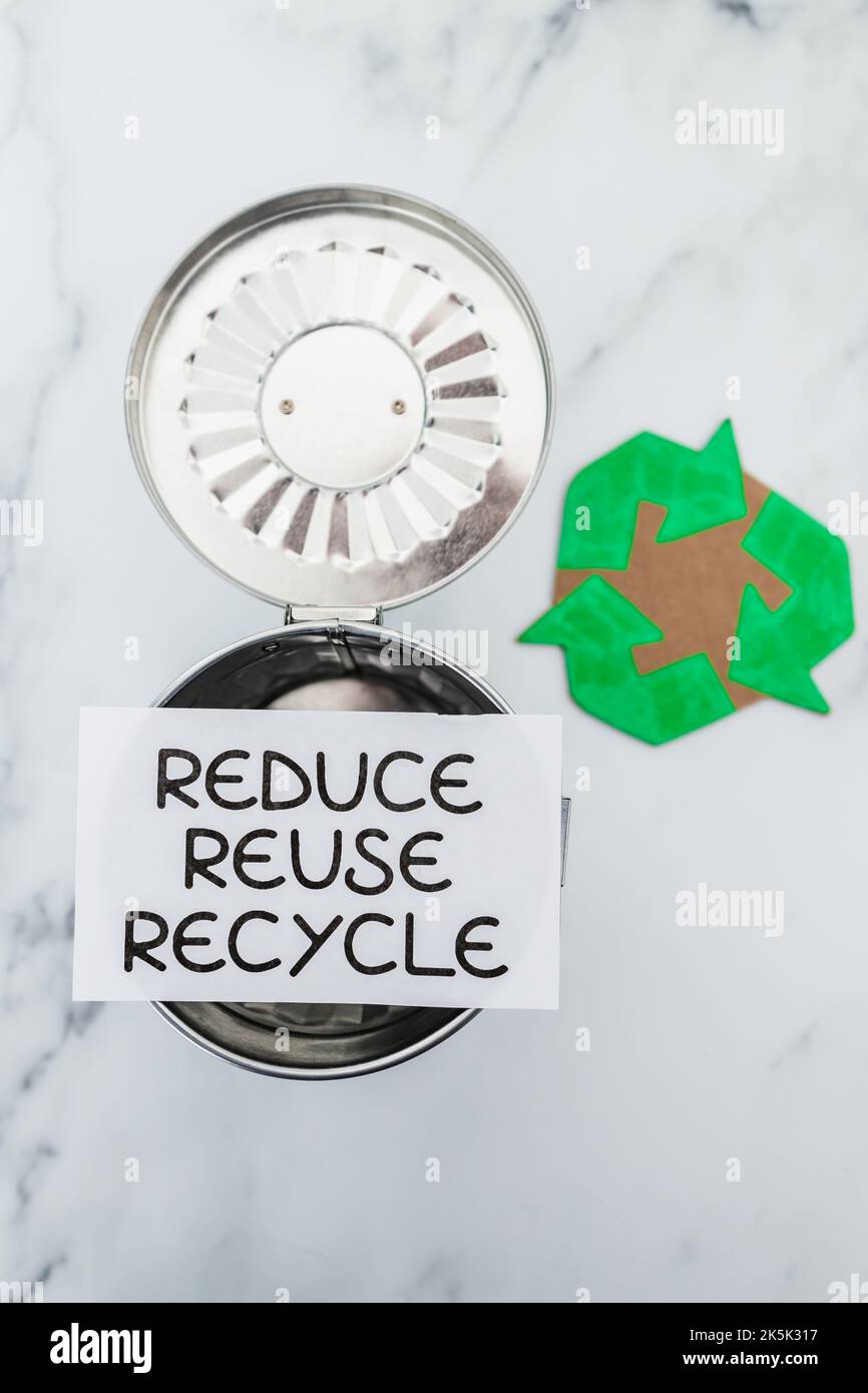 reduce reuse recycle sign with mini trash can next to recycle icon ...
