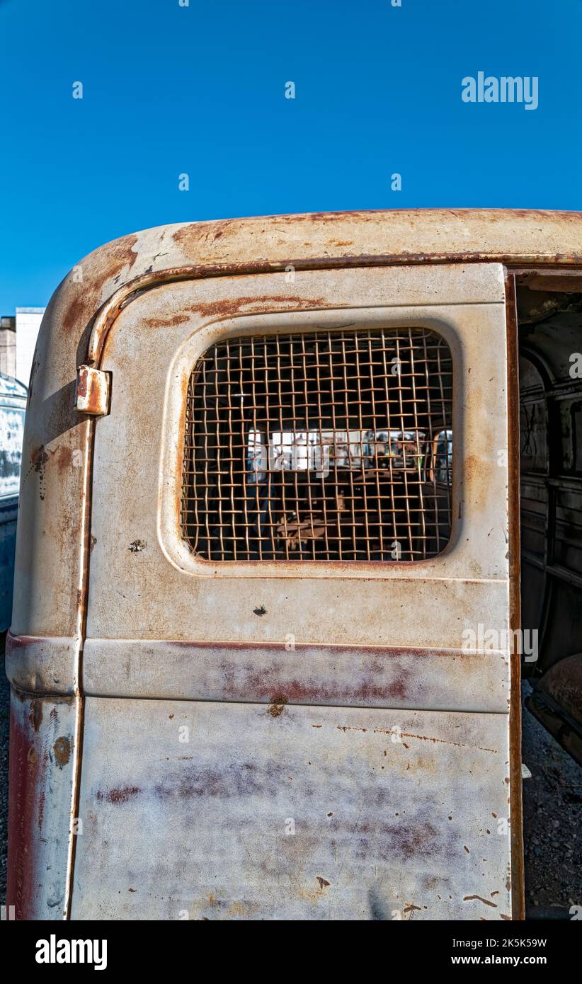 The metal mesh on the rear window on an abandoned antique panel truck Stock Photo