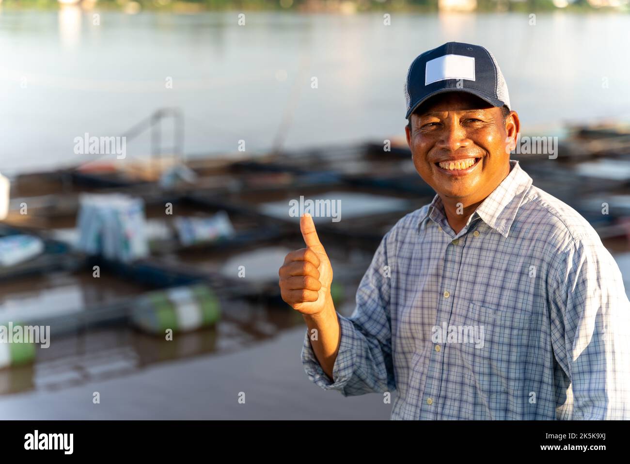 Asian happy aquaculture farmers at ponds and cages. Tilapia Farming. Tilapia fish. Stock Photo