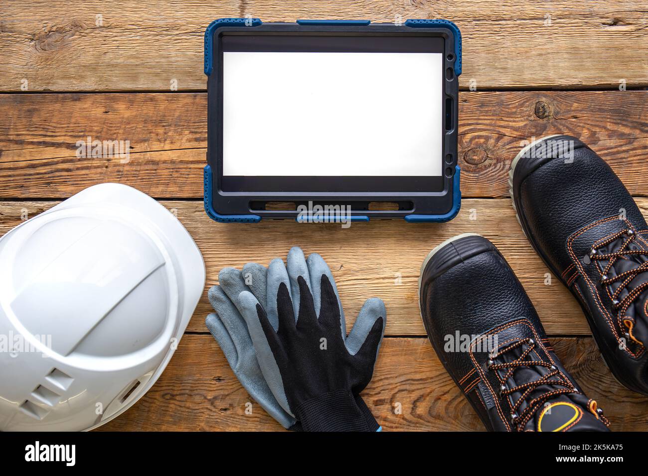 Builder uniform and digital tablet on wooden background, flat lay Stock ...