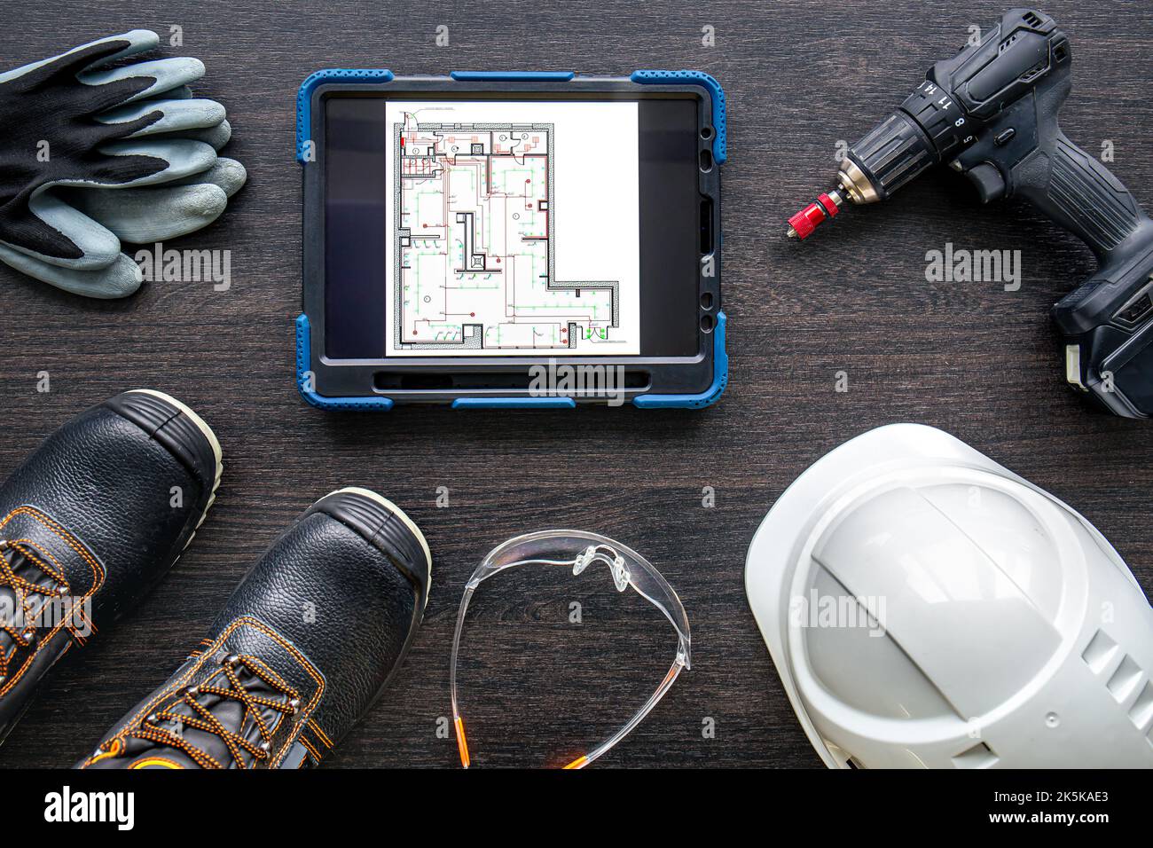 Digital tablet with layout and worker clothes, top view. Stock Photo