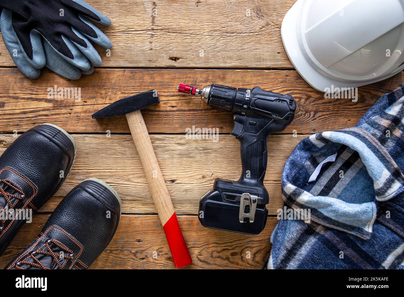 Uniform and construction tools on wooden table, top view. Stock Photo