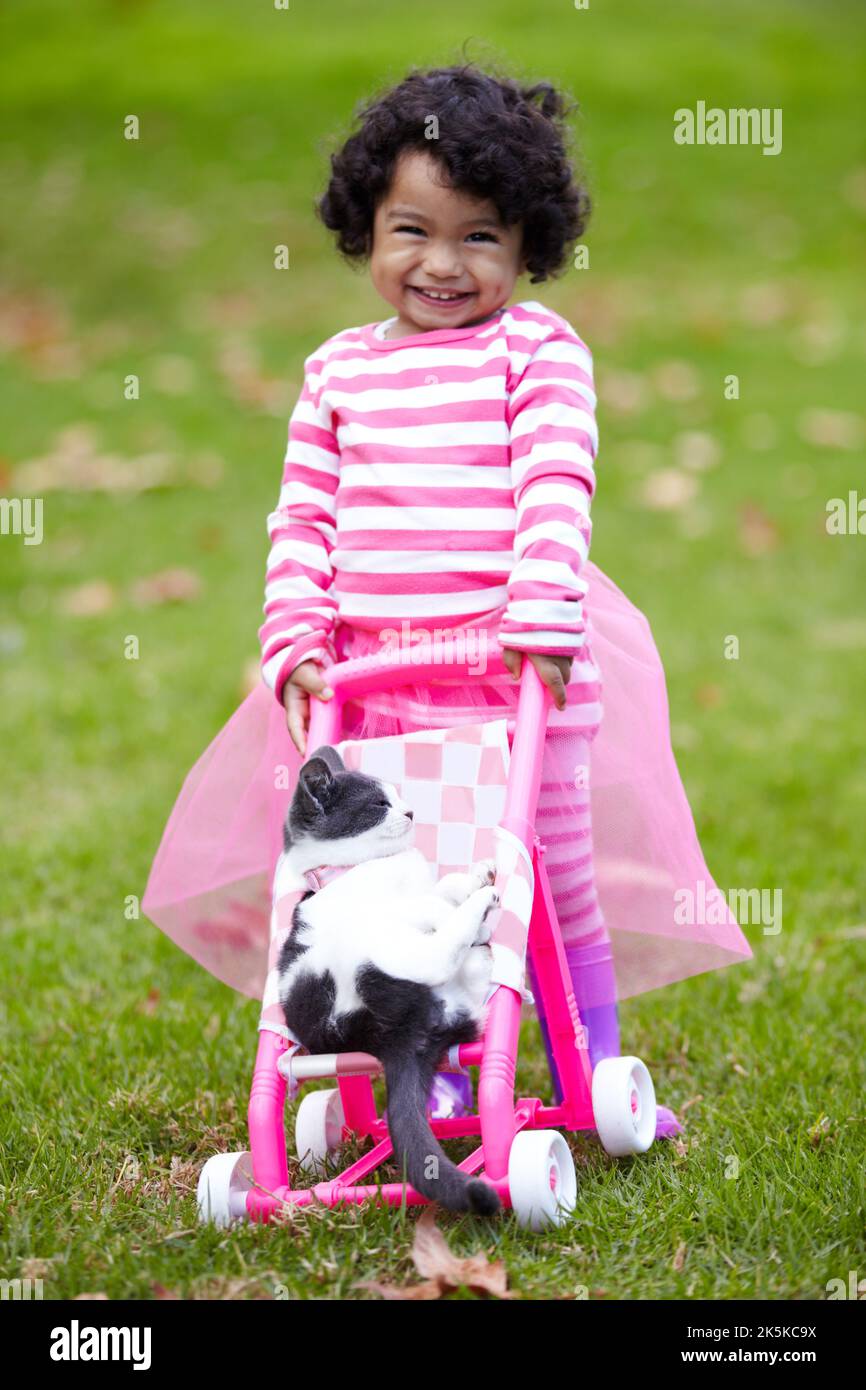 Theyre the best of playmates. Cute little girl pushing her kitten in a