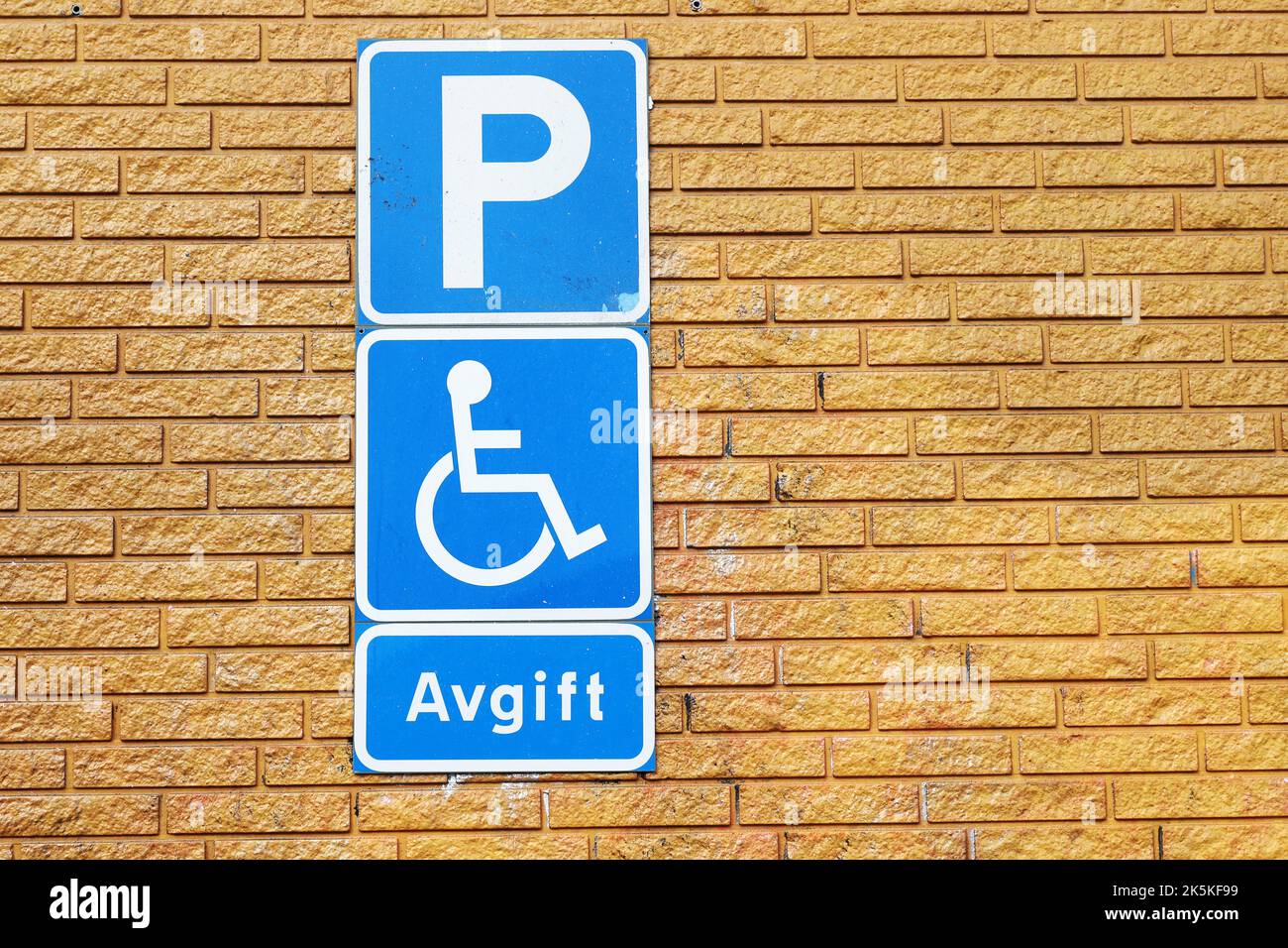 Swedish road signs indicate that parking is permitted for a fee if vehicle has a handicap permit. Stock Photo