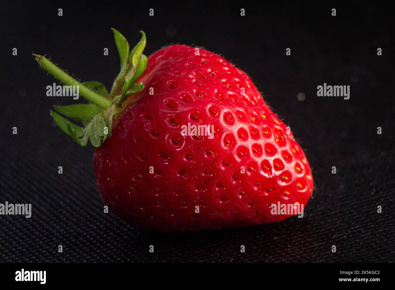Ripe red strawberry in the dark background Stock Photo - Alamy