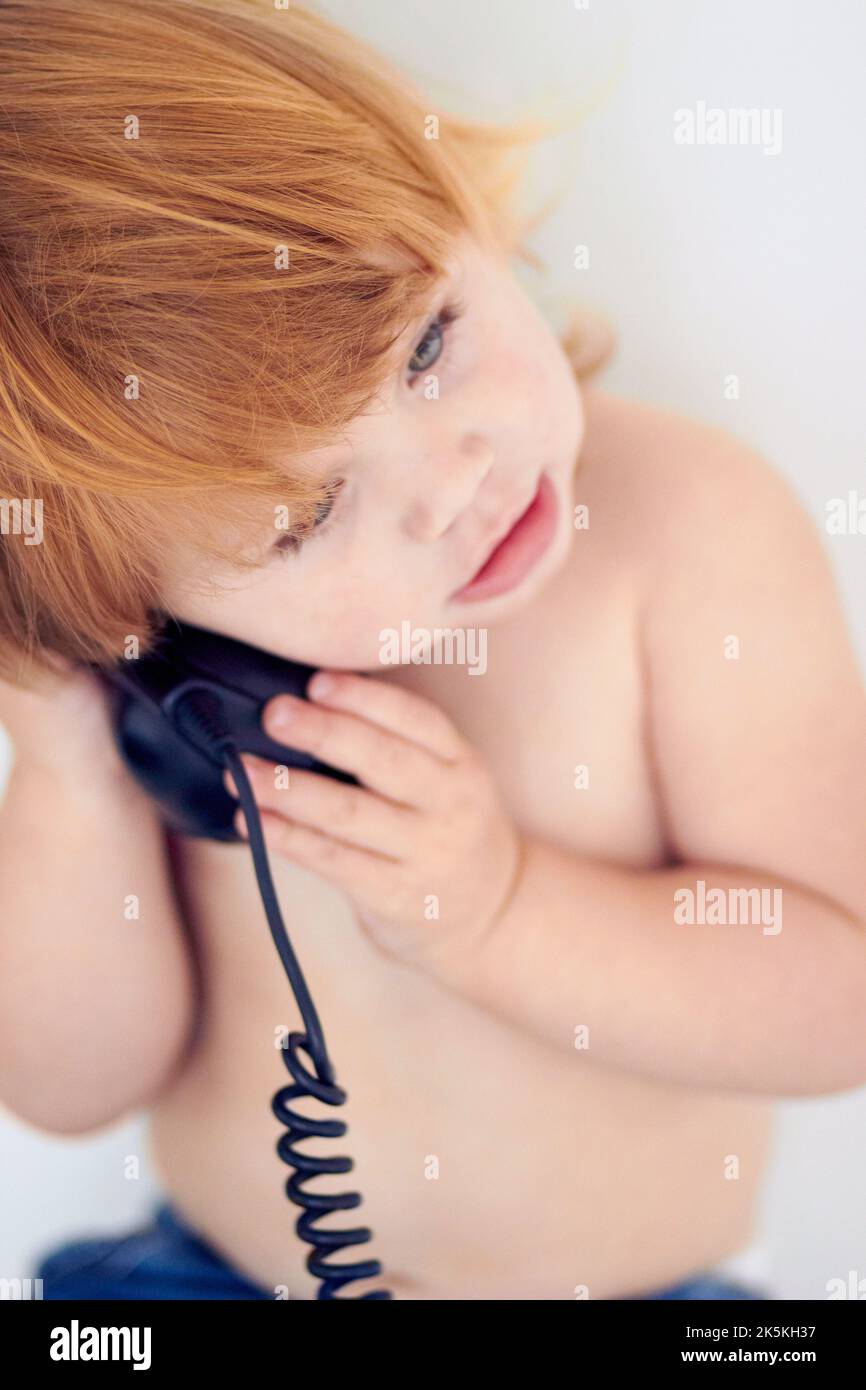 Is this Santa. a little girl talking on a landline phone. Stock Photo