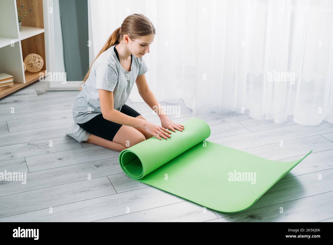 kids fitness training home gym girl rolling up mat Stock Photo Alamy