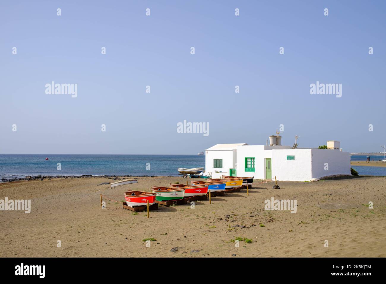 House by the sea with colorful little boats Stock Photo