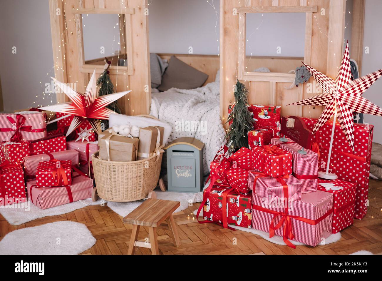 Children room with Christmas decorations. Presents in red festive packaging. Interior design for kids Stock Photo