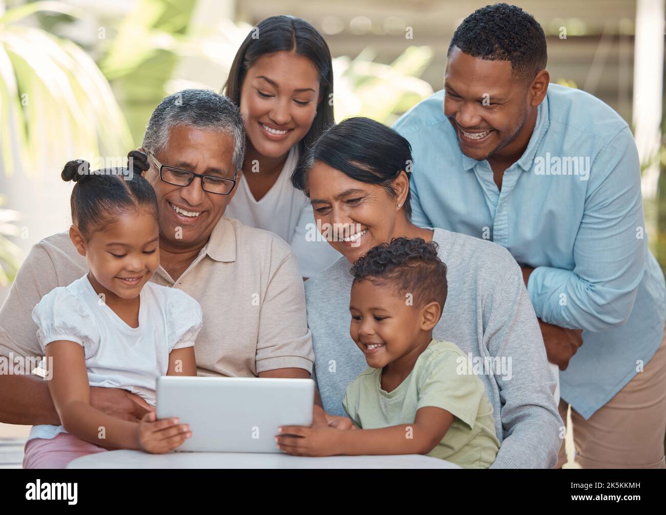 Family tablet, grandparents video call and children on internet with technology, reading social media notification and comic story online. Parents Stock Photo