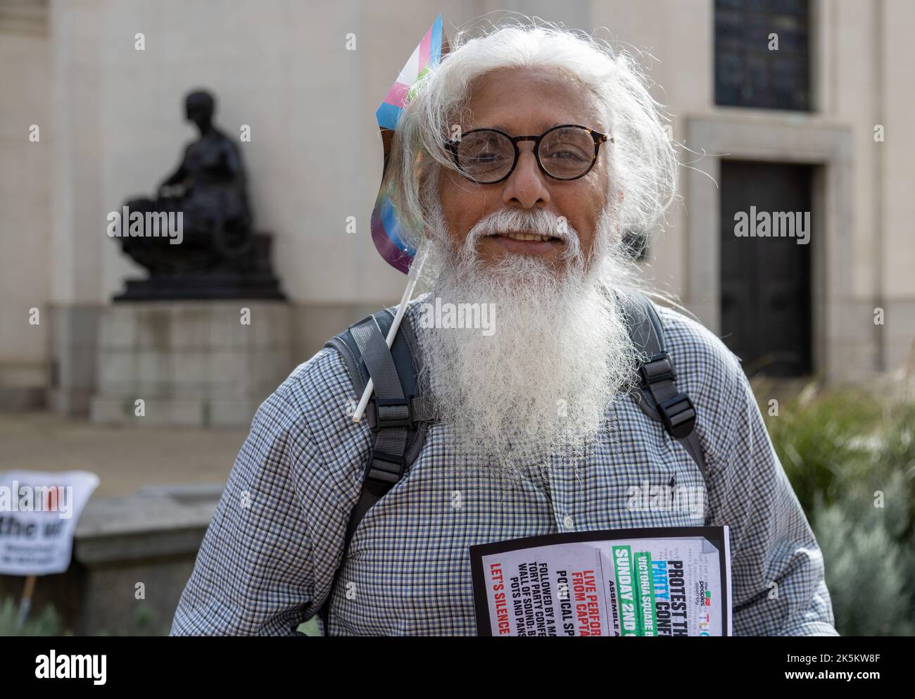 A supporter of The People's Assembly lobbies support to protest the Conservative Party conference in Birmingham. A man with long white hair and beard. Stock Photo