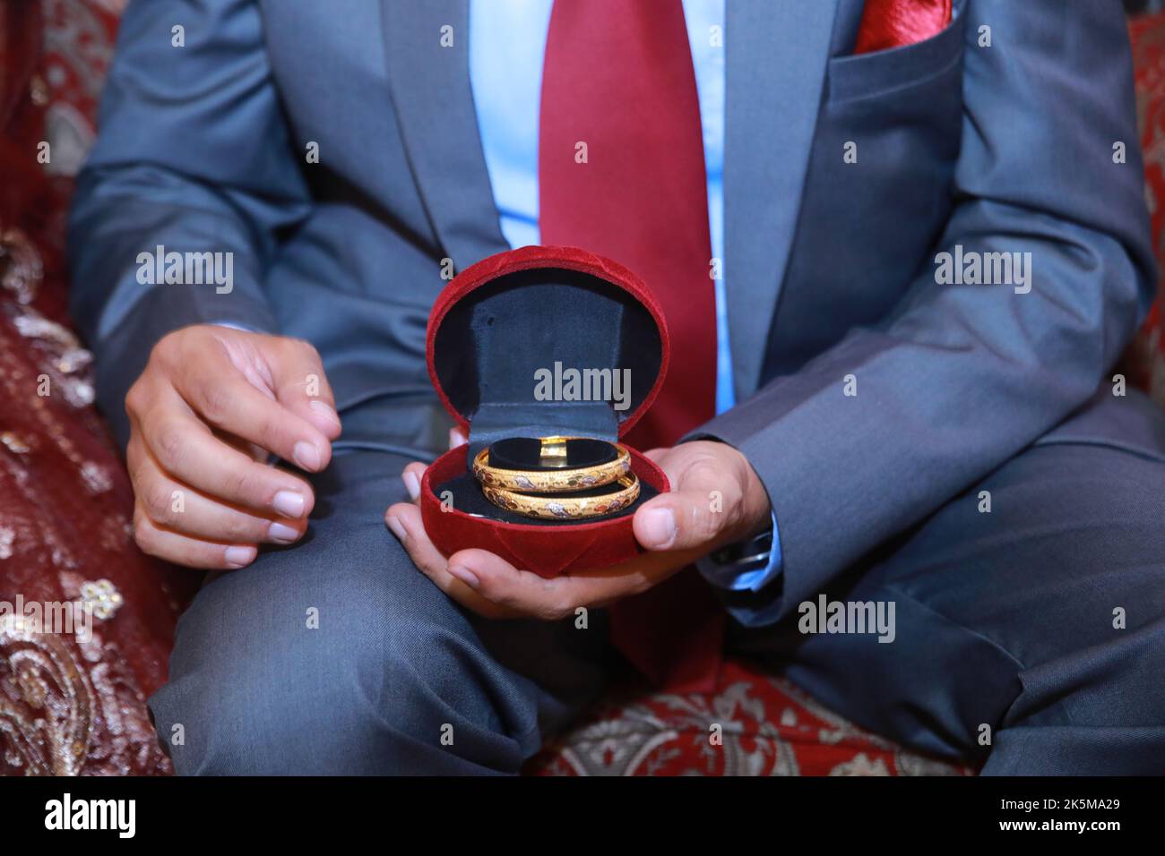 Groom presenting gold bangles to bride Stock Photo