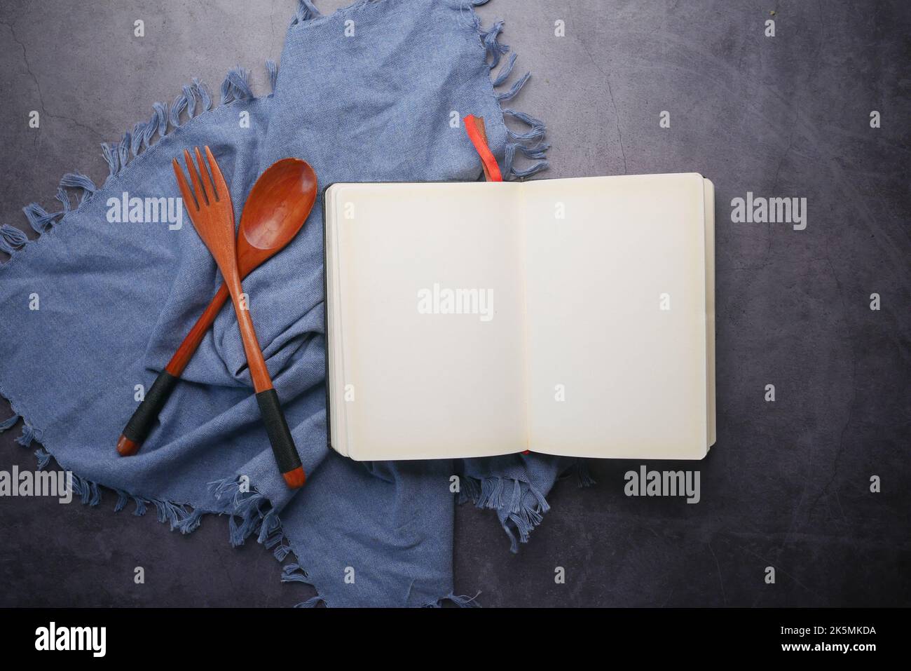 open notepad and wooden spoon on table cloth Stock Photo