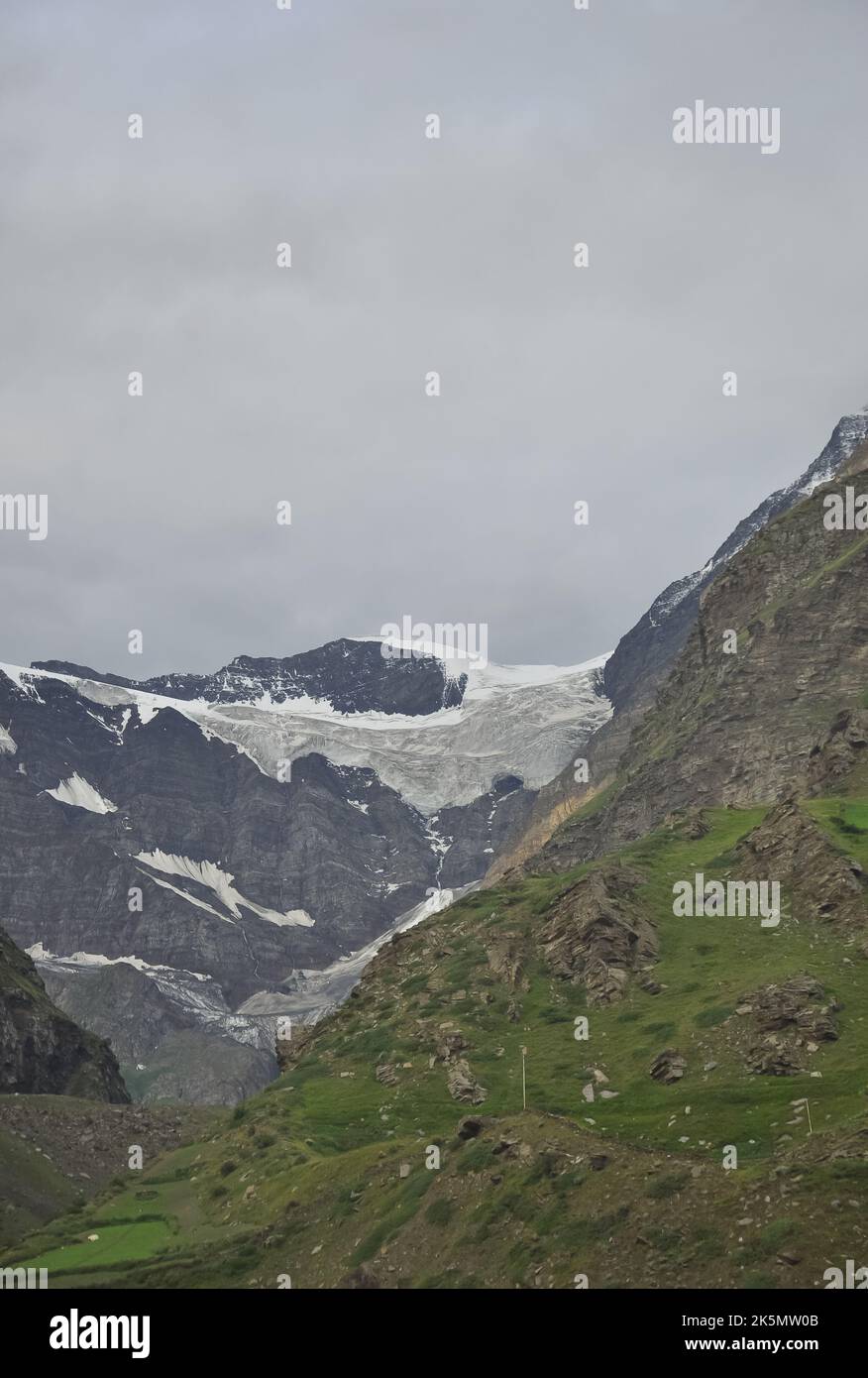 View of melting snow from rocky mountain during cloudy weather in Lahaul and Spiti, Himachal Pradesh, India. Stock Photo
