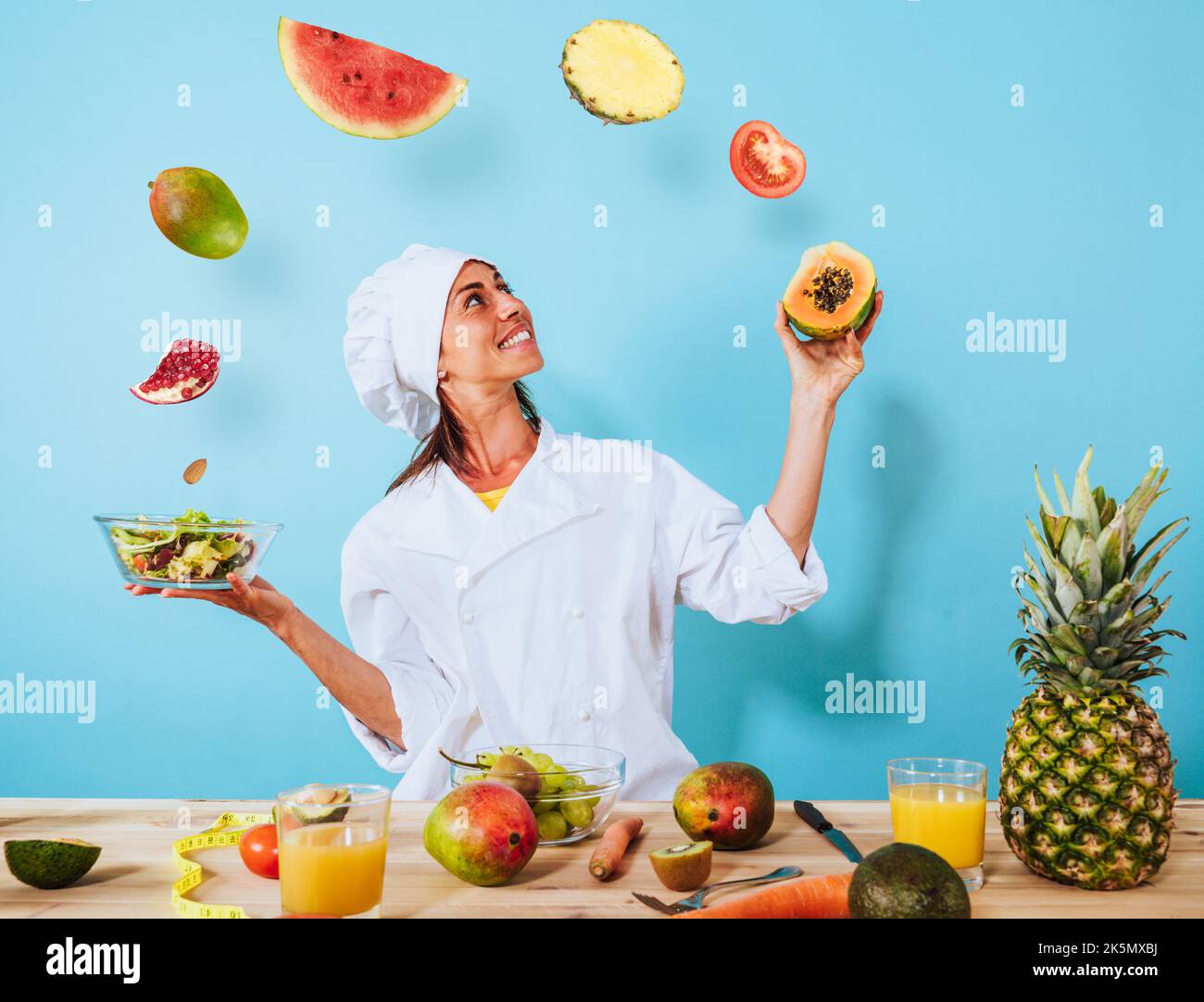 Woman chef prepares a new receipt with fruits Stock Photo