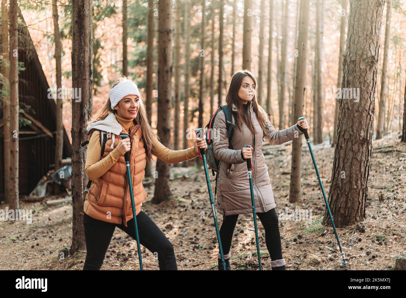 Two girls climbing up the hill together. Autumn colors Stock Photo - Alamy