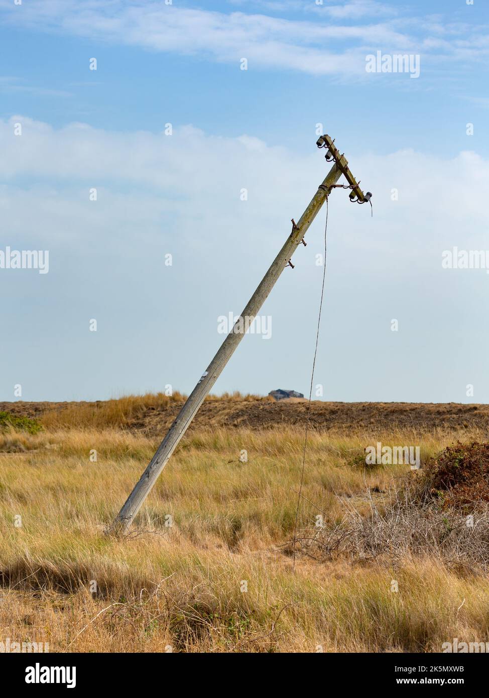 Leaning telegraph poll in a flat landscape, Orford Ness, Suffolk, England Stock Photo