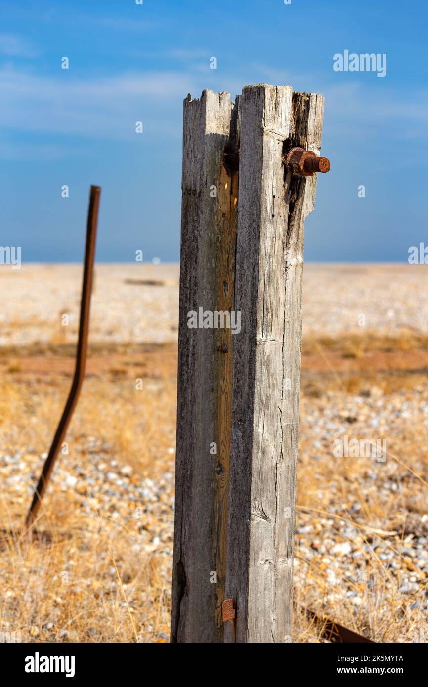 A wooden post standing in a flat coastal, shingle landscape, Orford Ness, Suffolk, England Stock Photo