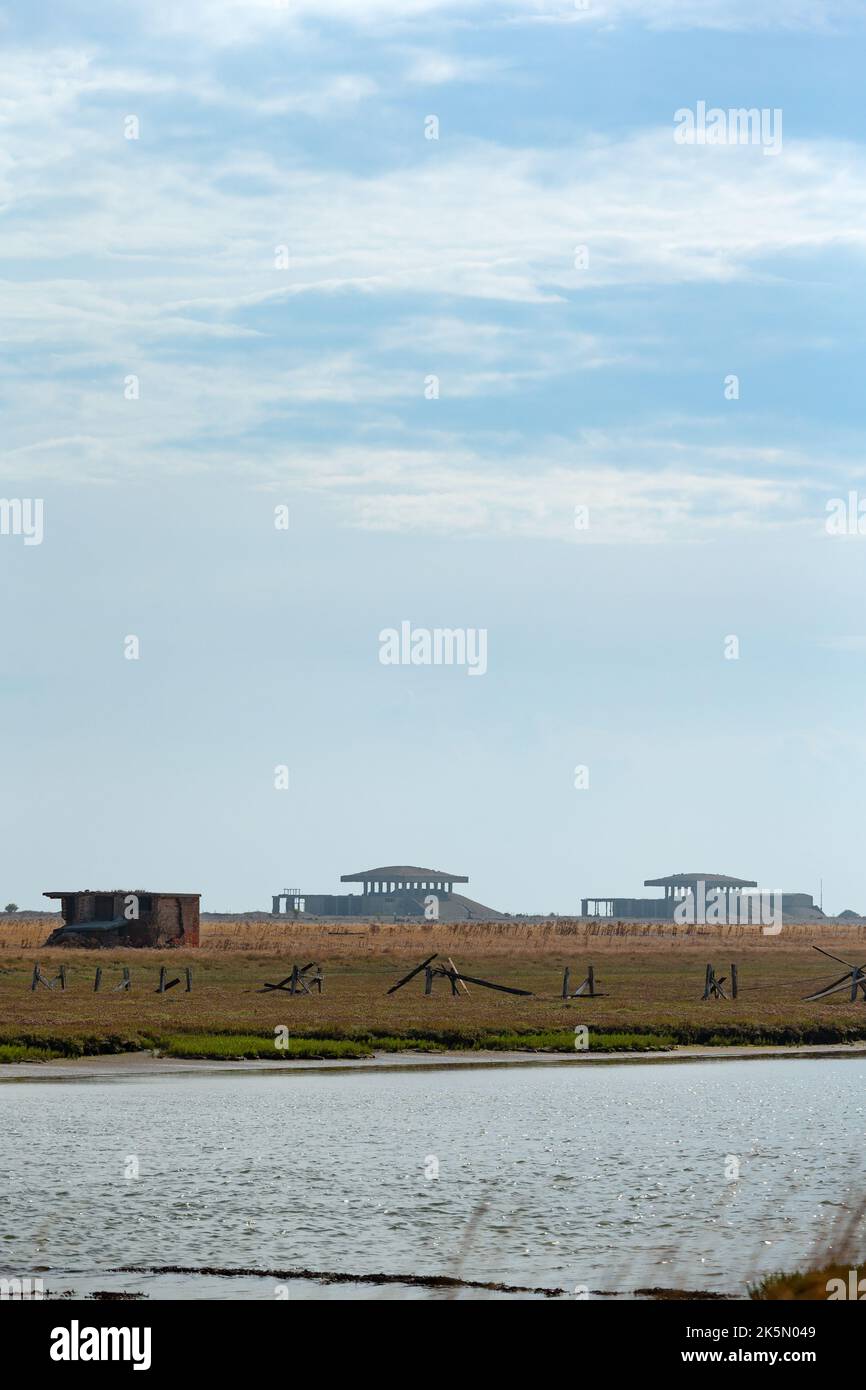 Landscape with atomic weapons research laboratory buildings with 'pagoda' blast roofs in the distance, Orford Ness, Suffolk, England Stock Photo