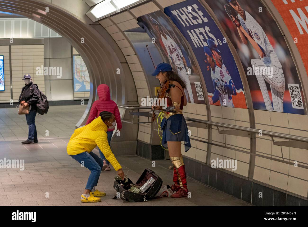 NEW YORK, NEW YORK - OCTOBER 08: A woman dressed as Wonder Woman plays violin during New York Comic Con 2022 at the Hudson Yards subway station on October 08, 2022 in New York City. Credit: Ron Adar/Alamy Live News Stock Photo