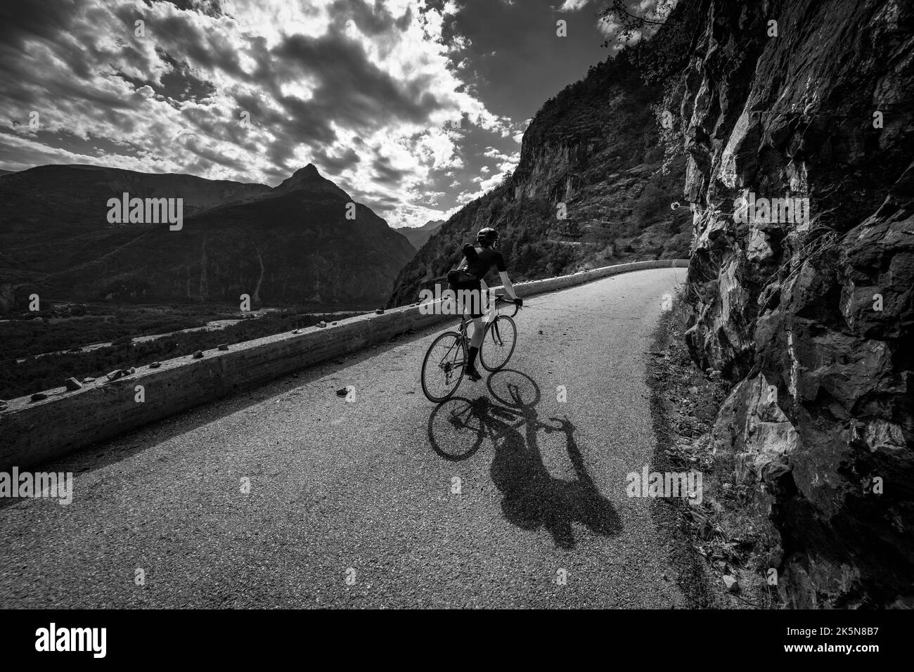 Male road cyclist riding up the balcony road from Bourg d'Oisans to Villard Notre Dame, French Alps. Stock Photo