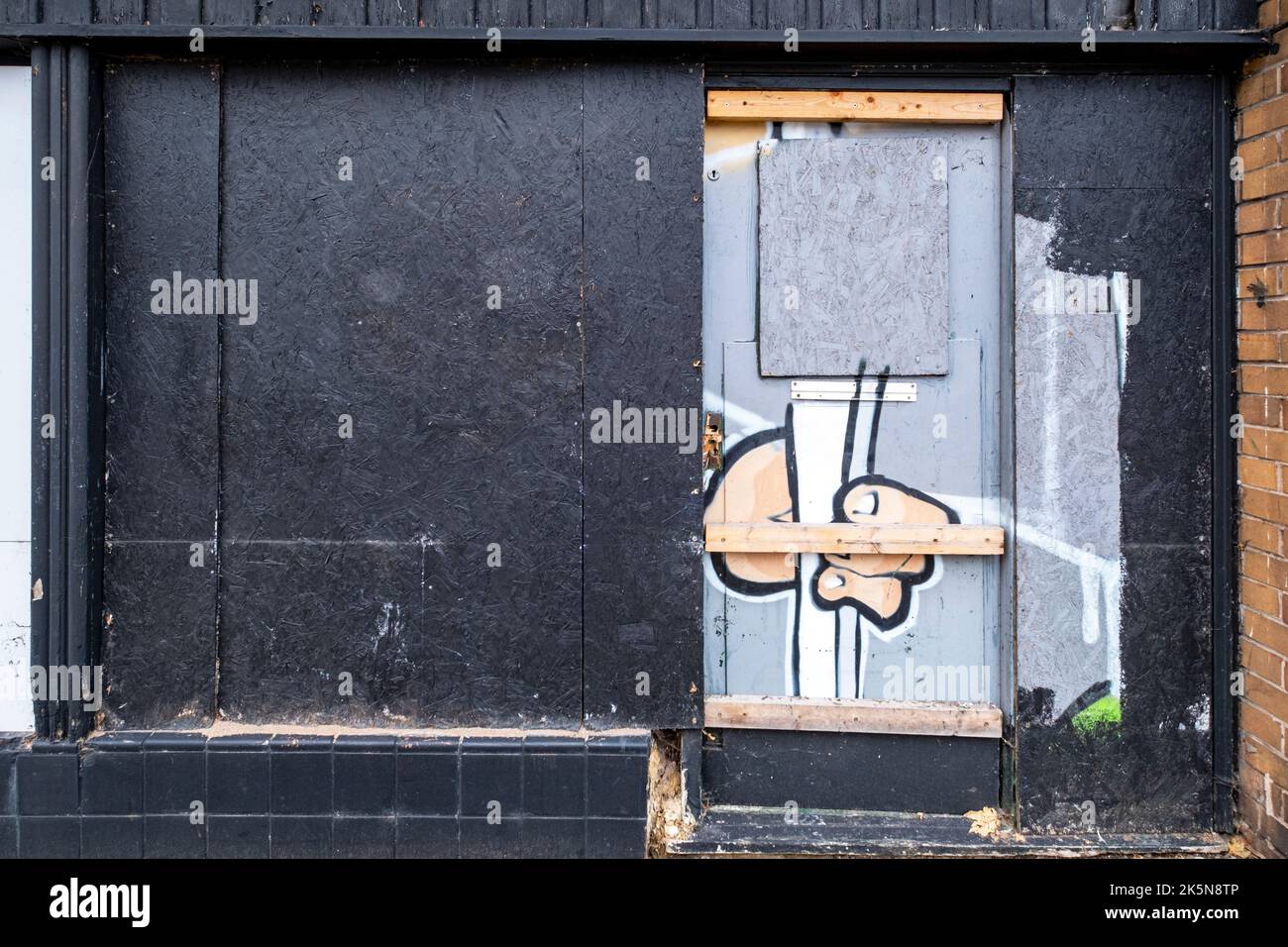 Graffiti on boarded up shop in Congleton Cheshire UK Stock Photo