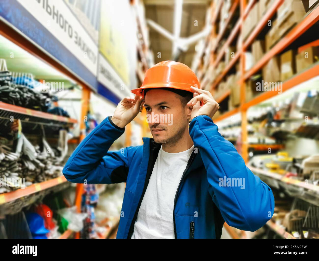 a man measures a helmet in a store Stock Photo