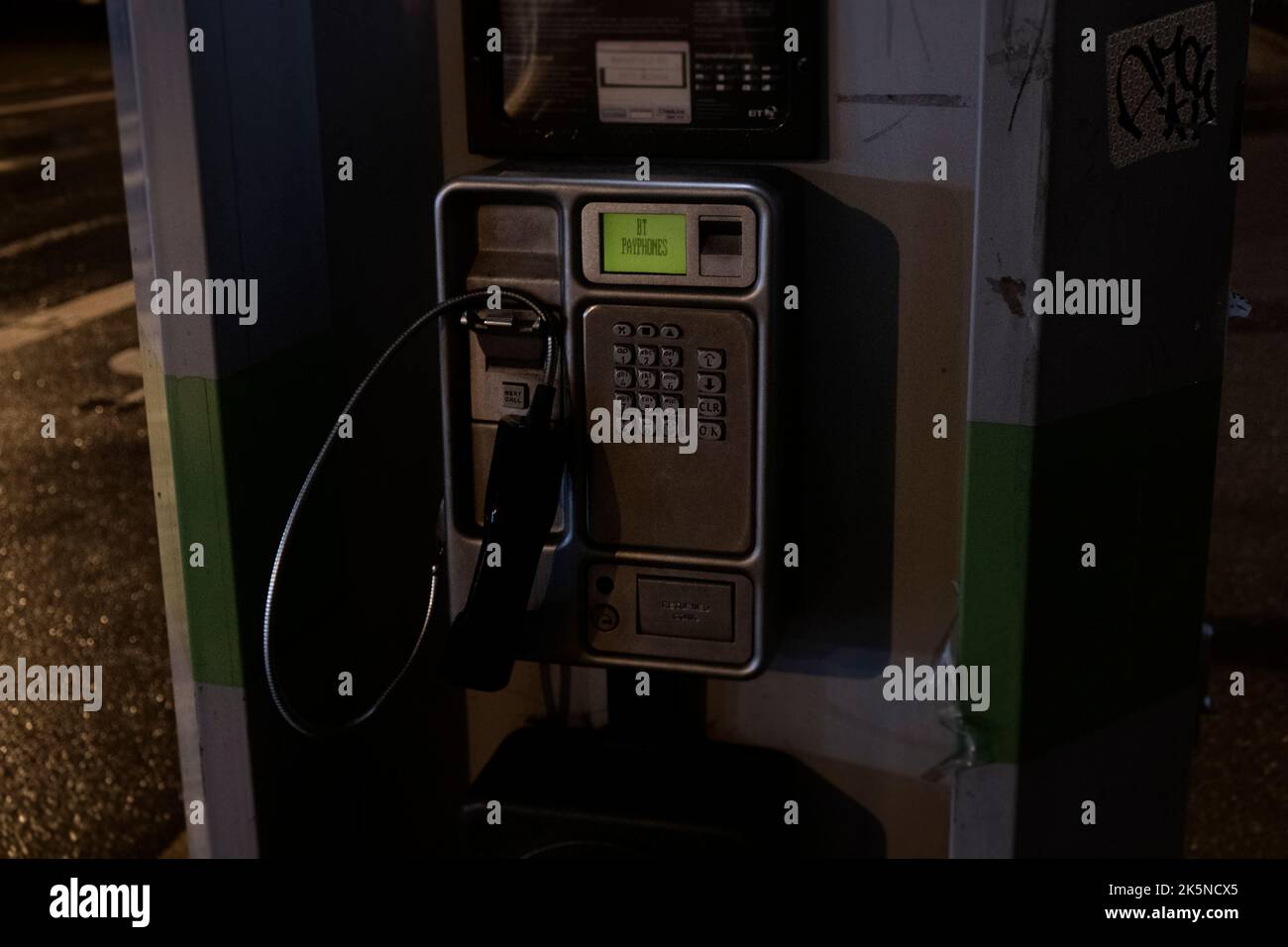 A phonebox is seen in a British city with the receiver off the hook ...