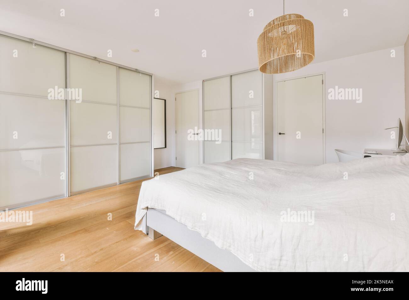 Home interior design of bedroom with bed and wooden wardrobe placed in