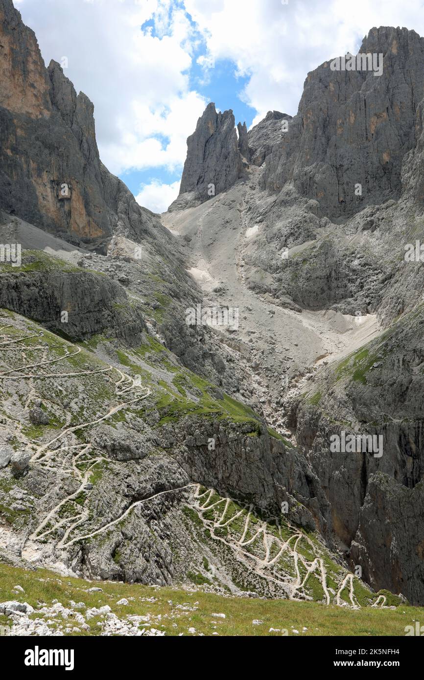 path that descends zigzag on the slope of the Italian alps in summer without people Stock Photo