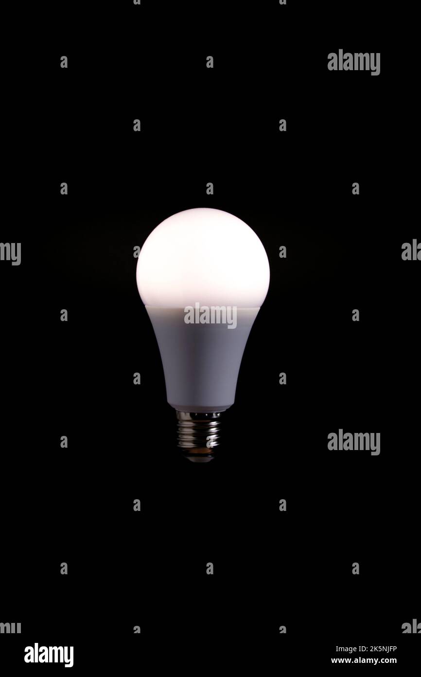 Burning LED eco friendly light bulb on black background Stock Photo