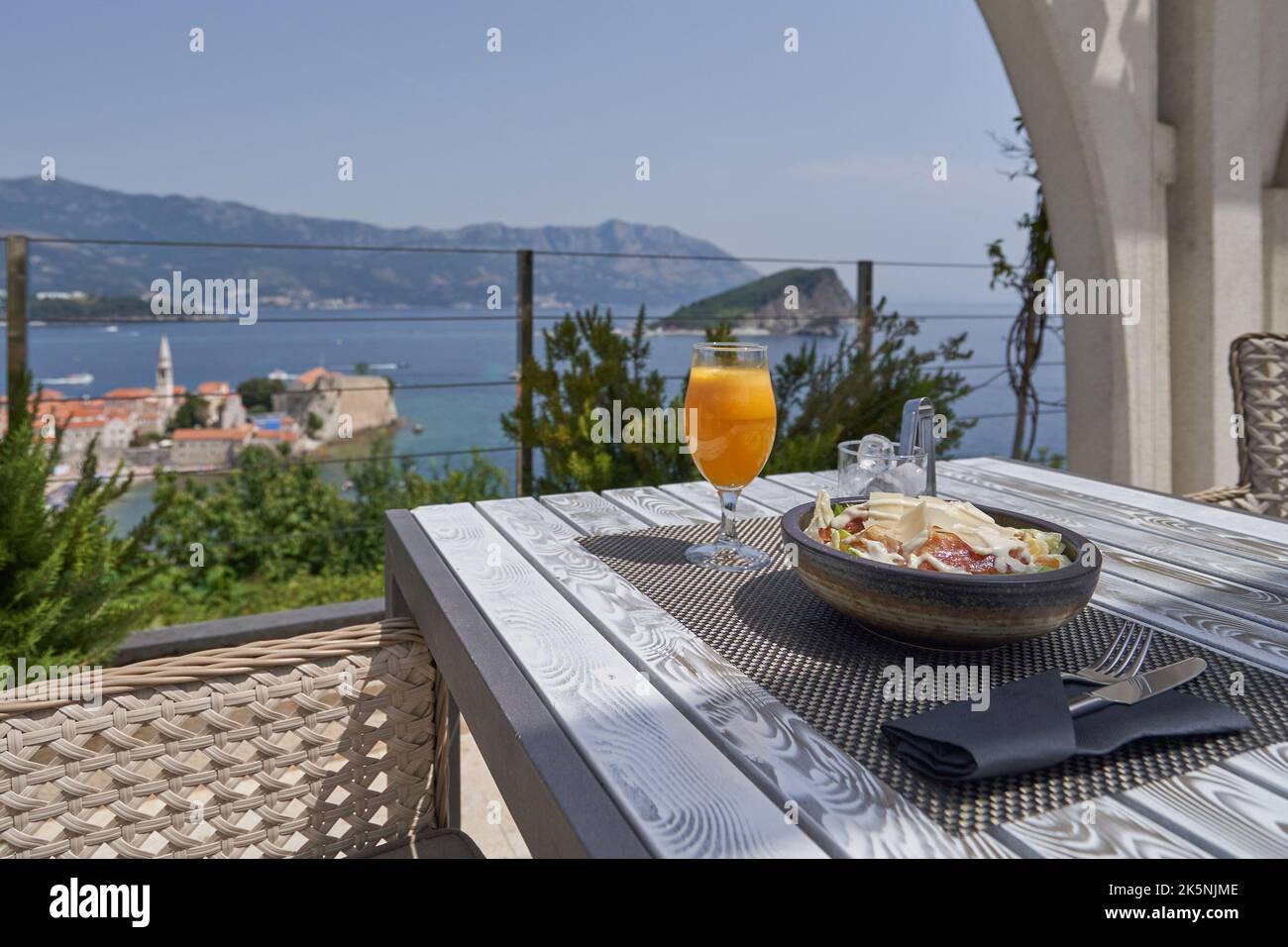 Breakfast and fresh juice on the table in a restaurant with sea view. Stock Photo