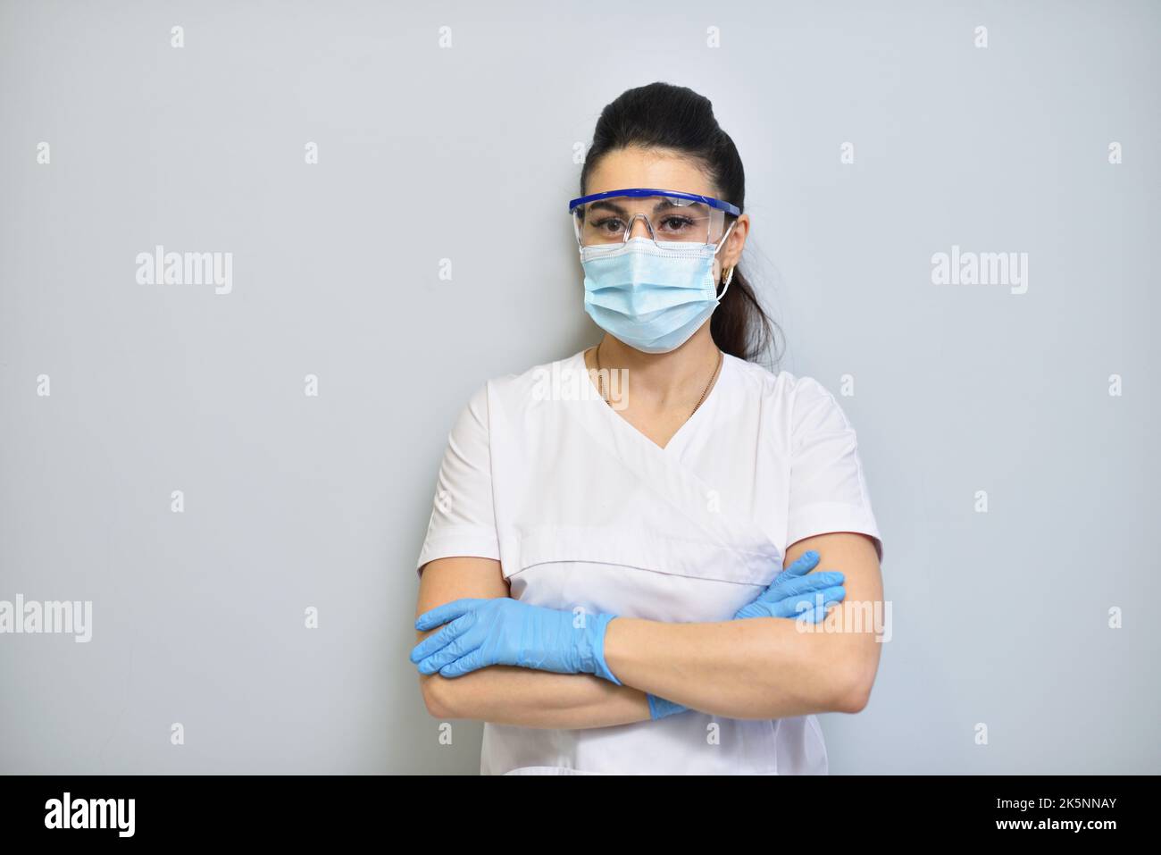 Cute woman dentist in uniform, protective glasses and face mask. Stock Photo