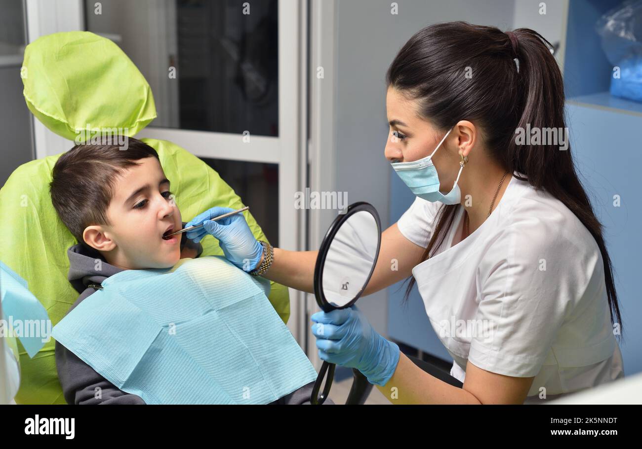 Dentist examines a child's teeth before treatment. Stock Photo
