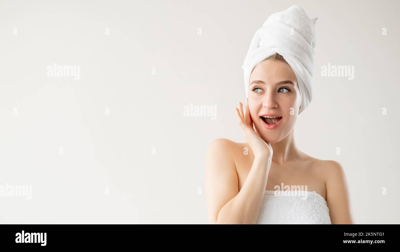 Anti-aged treatment. Amazed woman. Rejuvenation cosmetology. Advertising background. Pretty lady covering in towel posing isolated white copy space. Stock Photo
