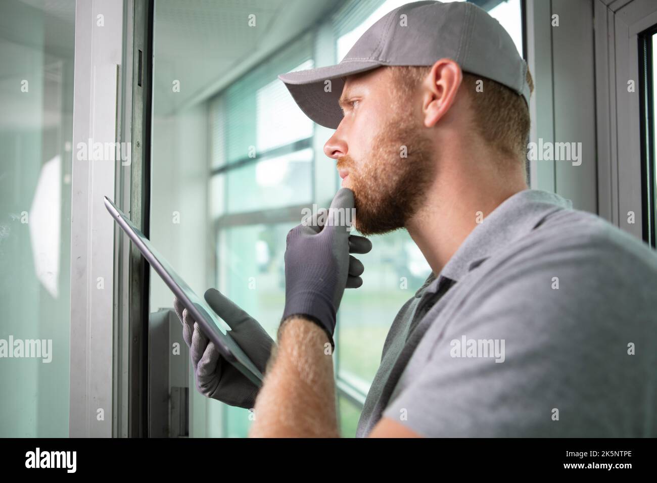 construction worker looking thoughtful while using digital tablet Stock Photo