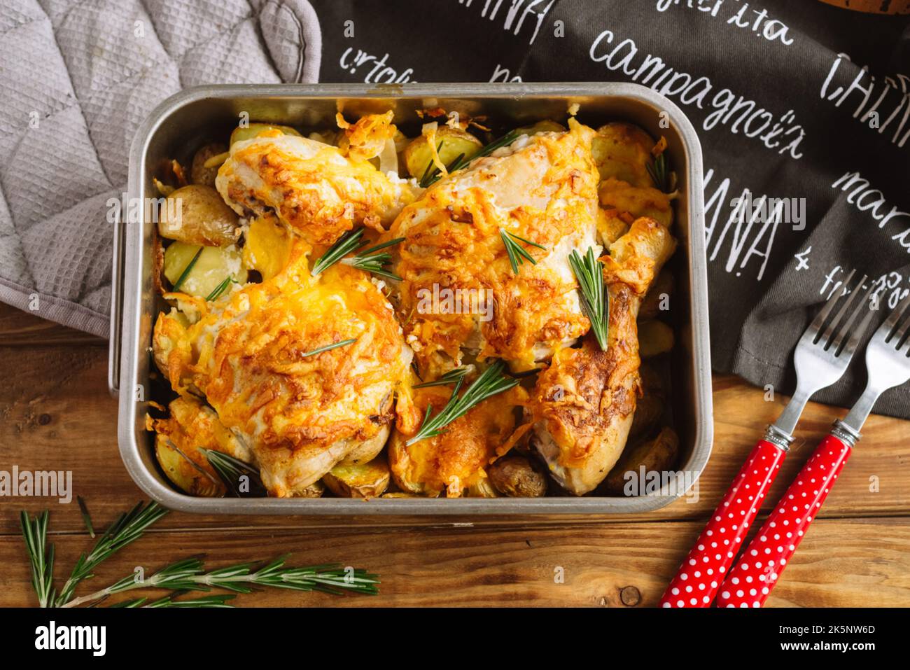 Chicken thighs baked with cheese on potato wedges and rosemary. Iron