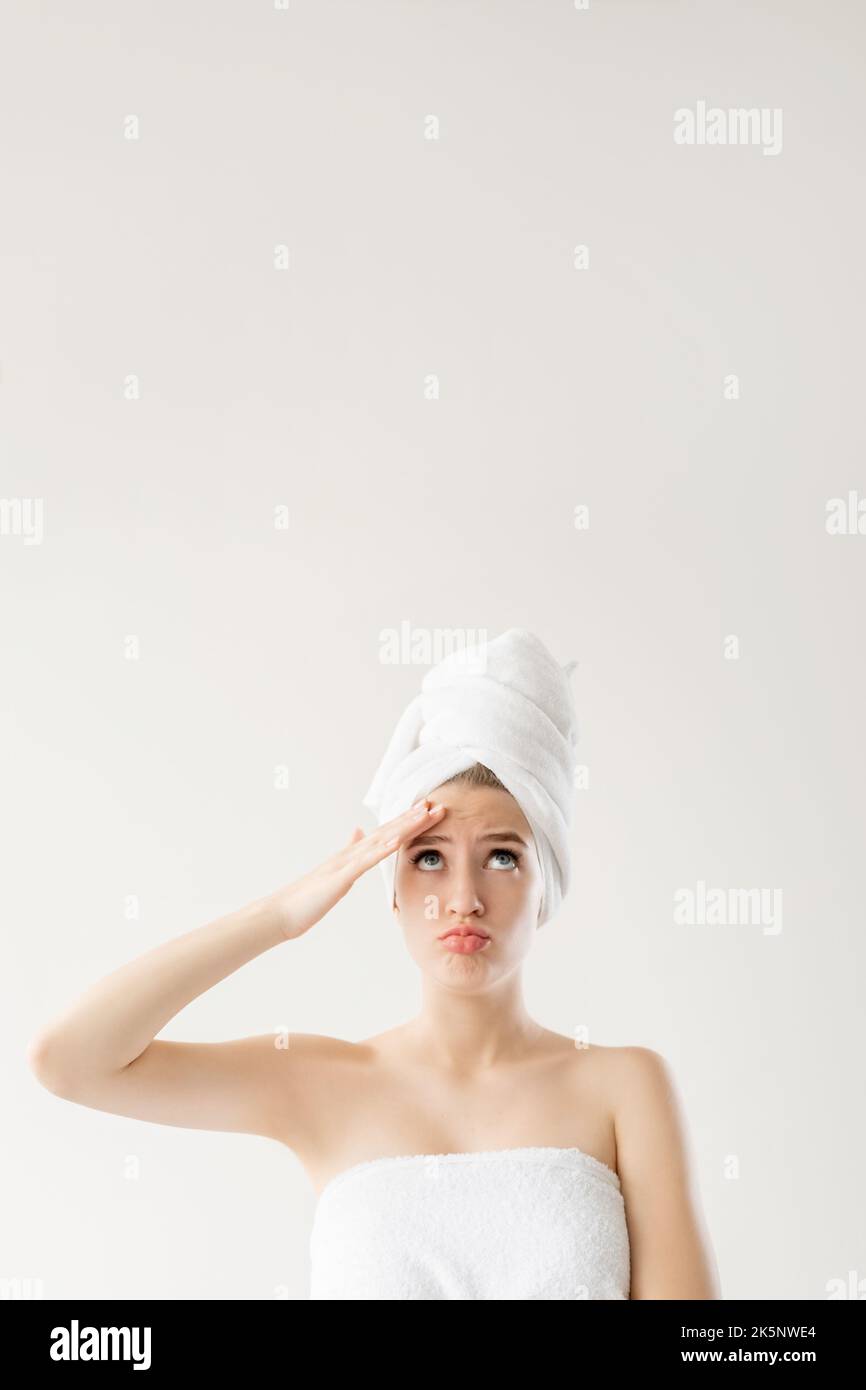Morning skin care. Puzzled woman. Anti-aged treatment. Pretty embarrassed lady touching forehead thinking about problem isolated white. Stock Photo
