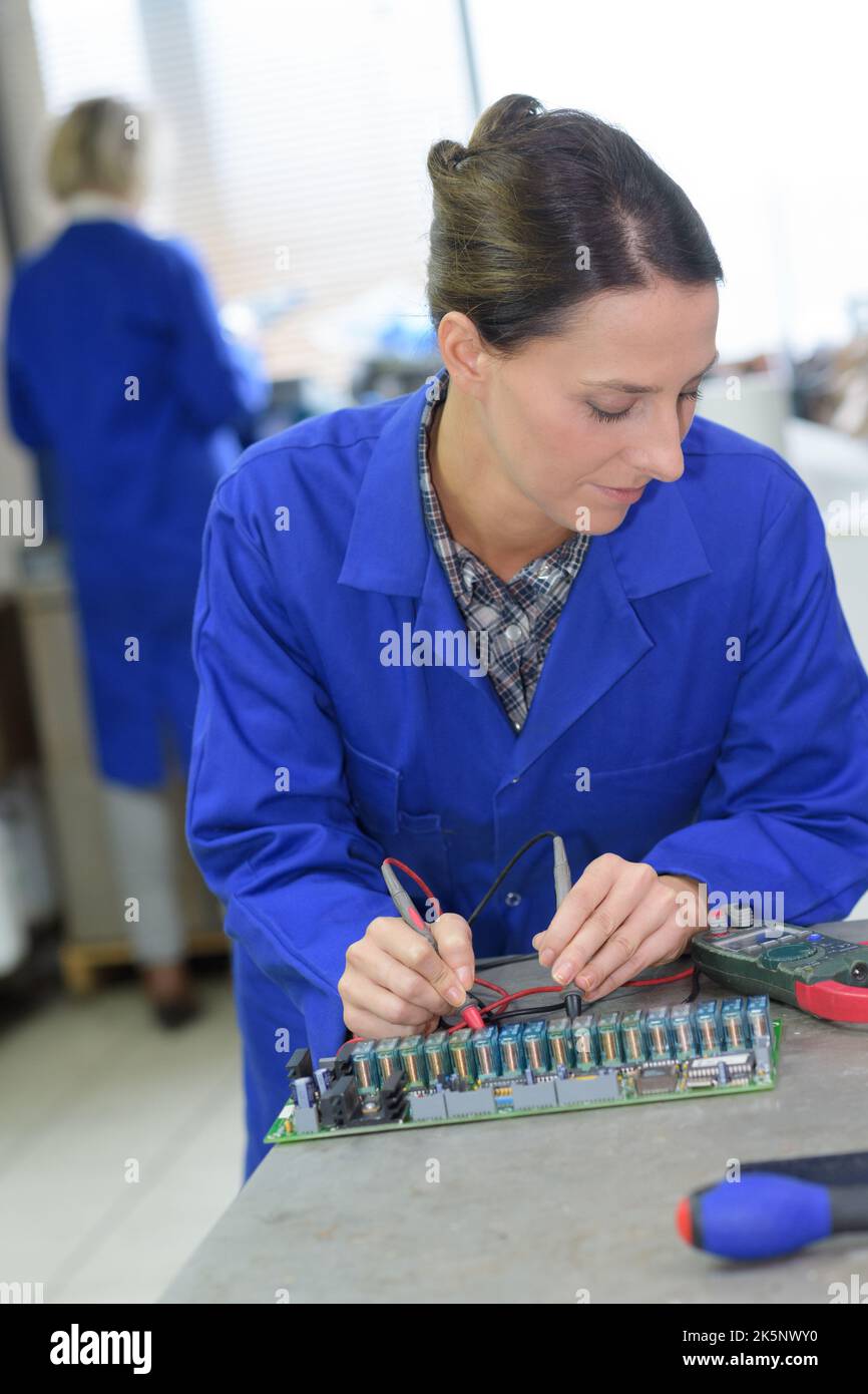 female electrician measuring voltage in distribution board closeup