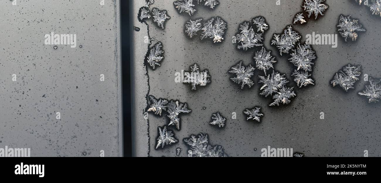 Ice crystals on the surface of a frozen glass during a cold winter day around Christmas in Finland. Beautiful holiday season closeup texture image. Stock Photo