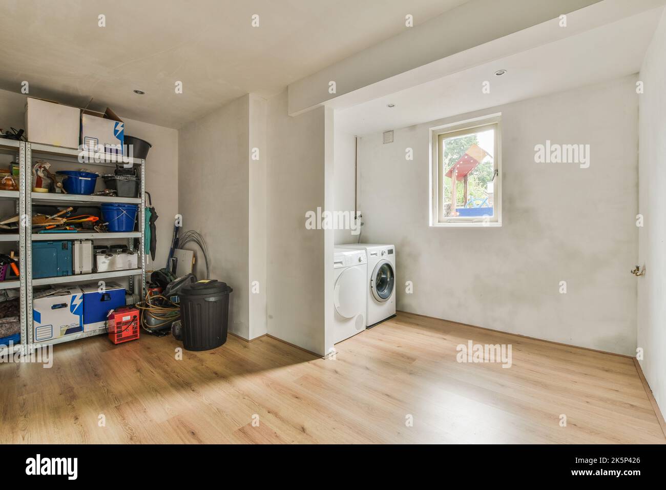 Modern cupboard, washing machine and Fridge near doors in spacious room