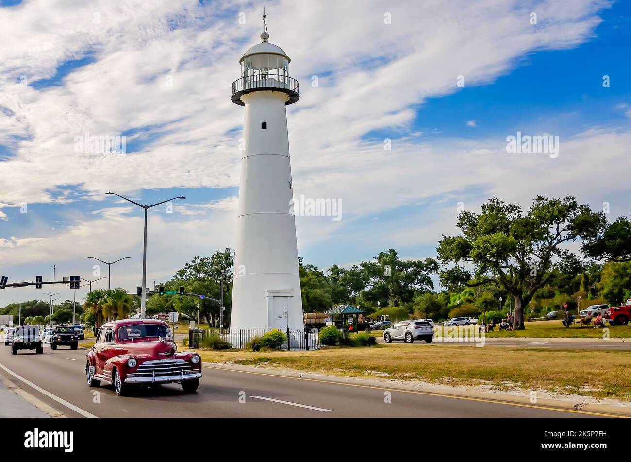 A vintage automobile passes the Biloxi lighthouse during the 26th annual Cruisin’ the Coast antique car festival, Oct. 4, 2022, in Biloxi, Mississippi. Stock Photo