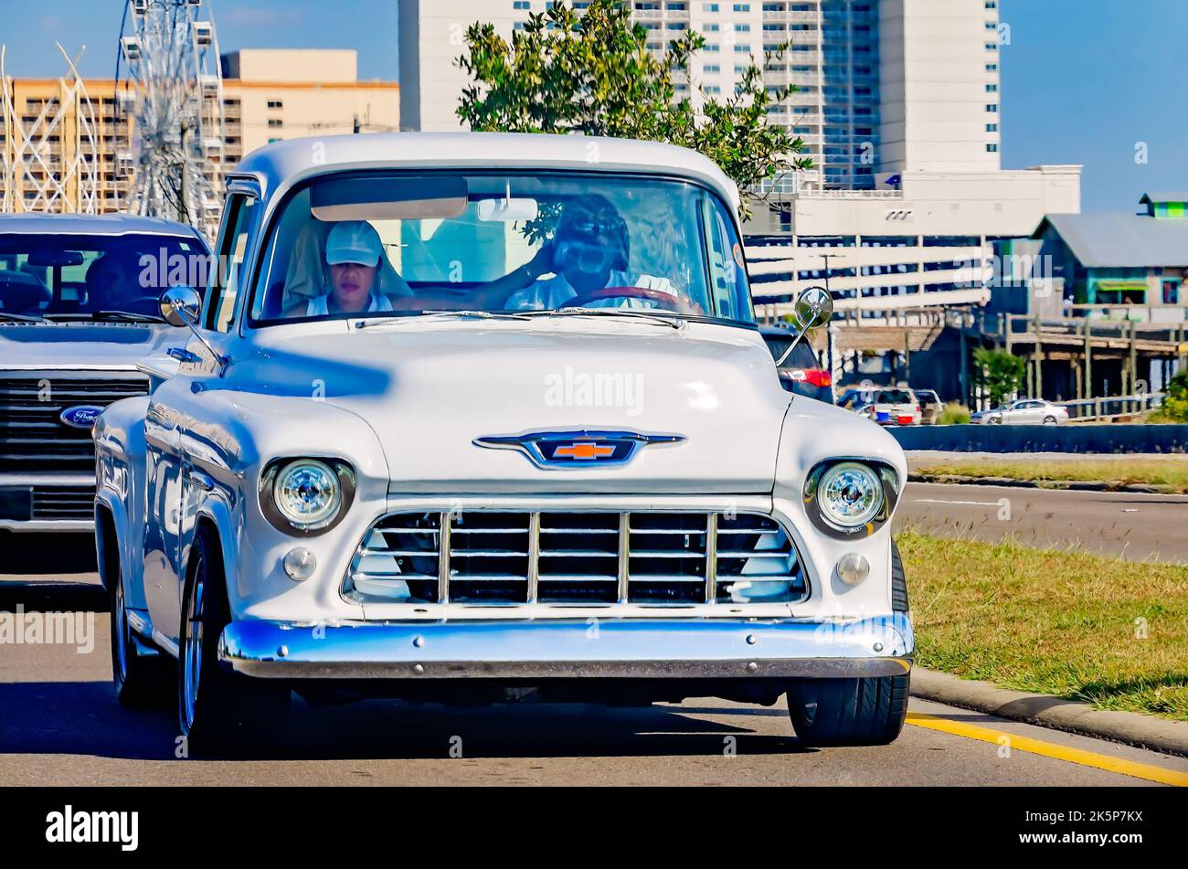 A vintage Chevrolet pickup truck drives down Highway 90 during the 26th