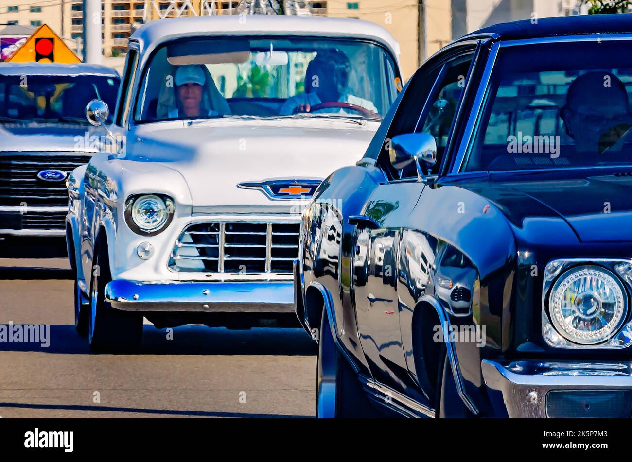 A vintage Chevrolet pickup truck drives down Highway 90 during the 26th