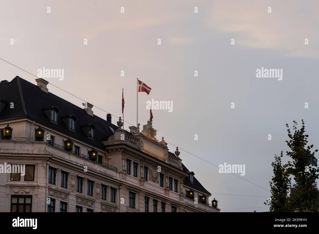 Copenhagen, Denmark. October 2022. The Danish flag flying on the roof of an ancient palace in the city center Stock Photo