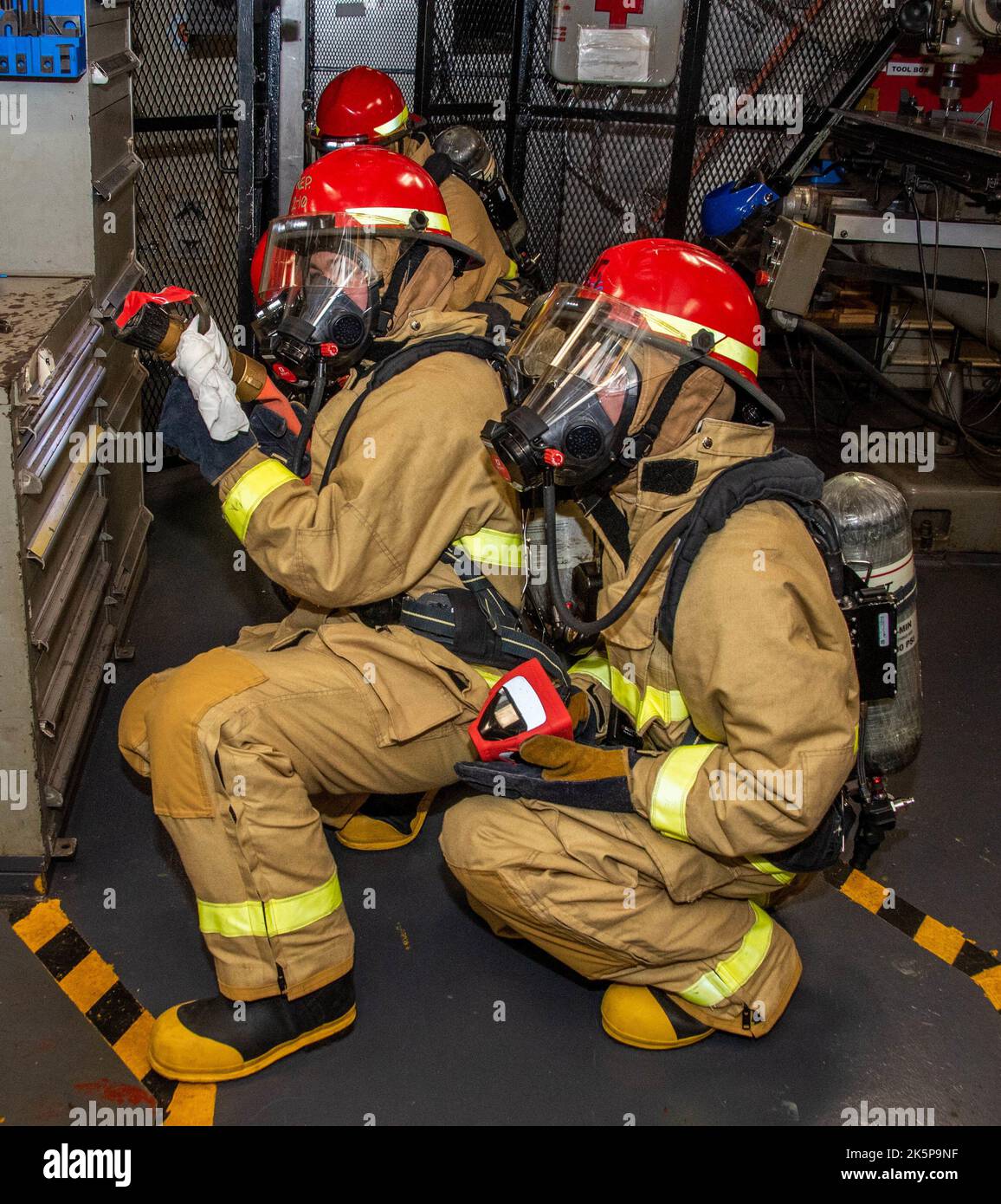 221008-N-BR419-1007 SEA OF JAPAN (Oct. 8, 2022) Sailors simulate extinguishing a fire in the machine repair shop during a general quarters drill aboard the U.S. Navy’s only forward-deployed aircraft carrier, USS Ronald Reagan (CVN 76), in the Sea of Japan, Oct. 8. Ronald Reagan, the flagship of Carrier Strike Group 5, provides a combat-ready force that protects and defends the United States, and supports alliances, partnerships and collective maritime interests in the Indo-Pacific region. (U.S. Navy photo by Mass Communication Specialist 3rd Class Oswald Felix Jr.) Stock Photo