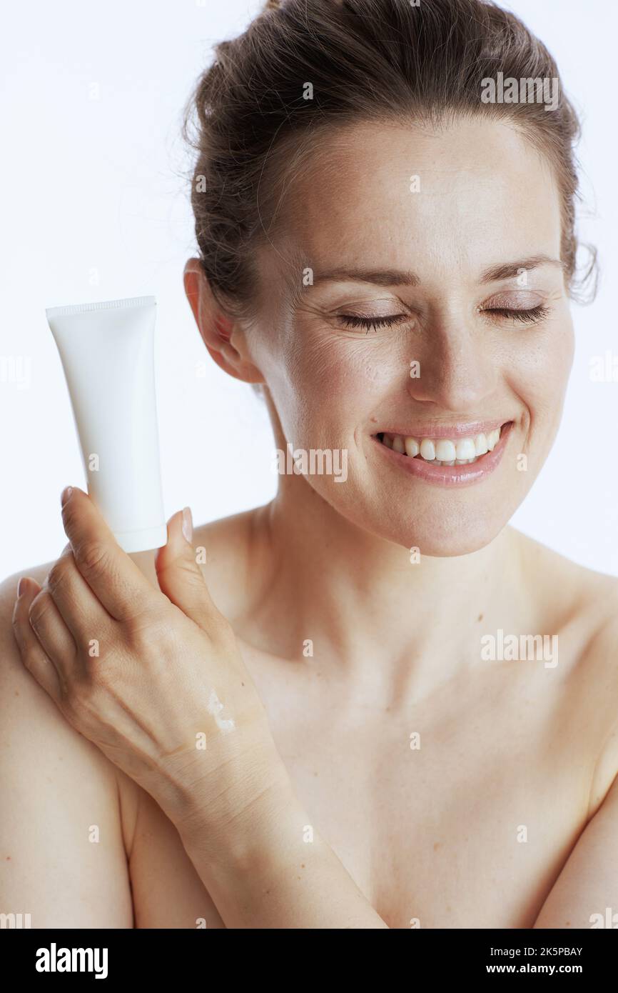happy 40 years old woman with cosmetic cream jar against white
