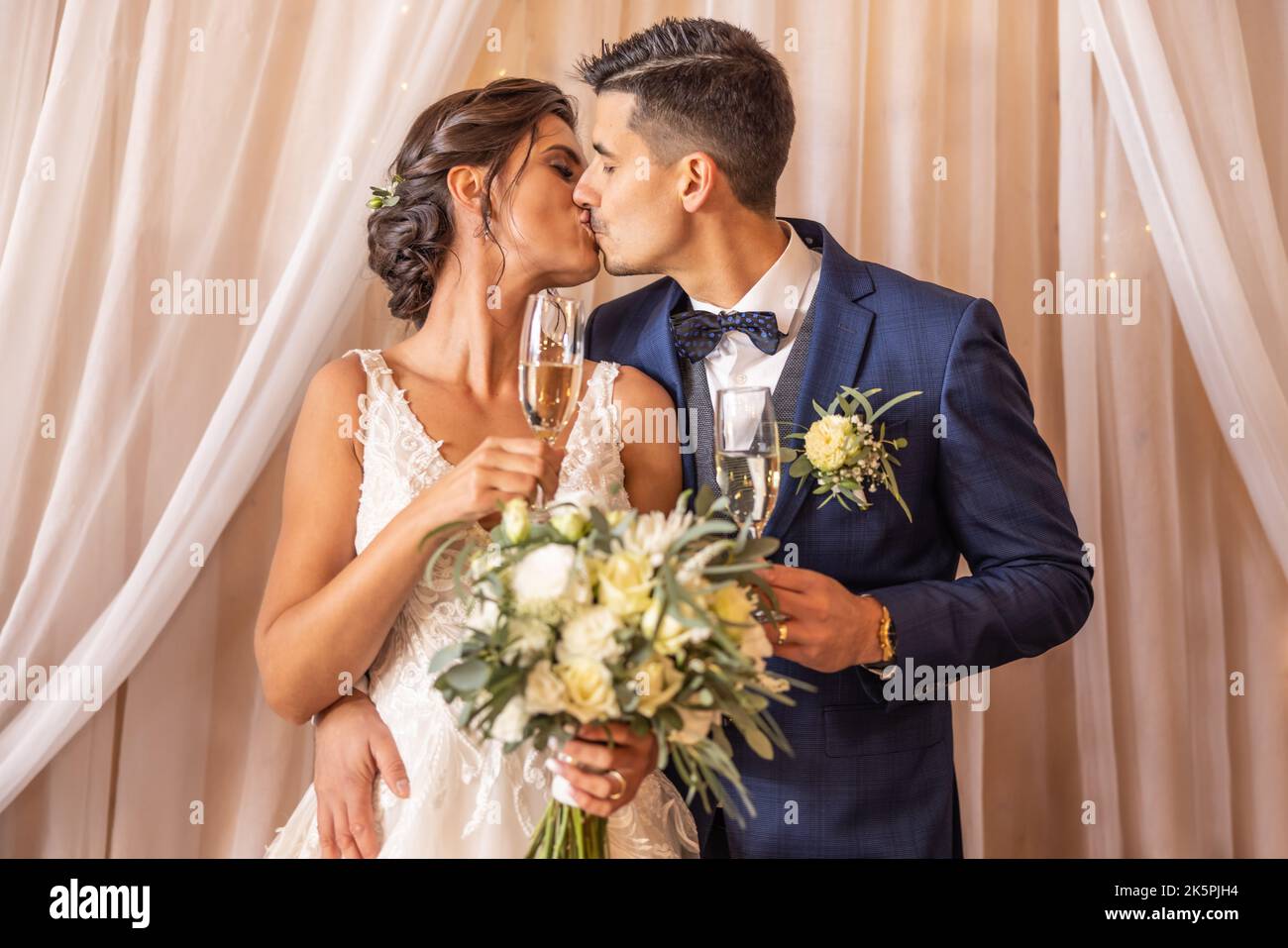 Newlyweds that just got married are having their first kiss with